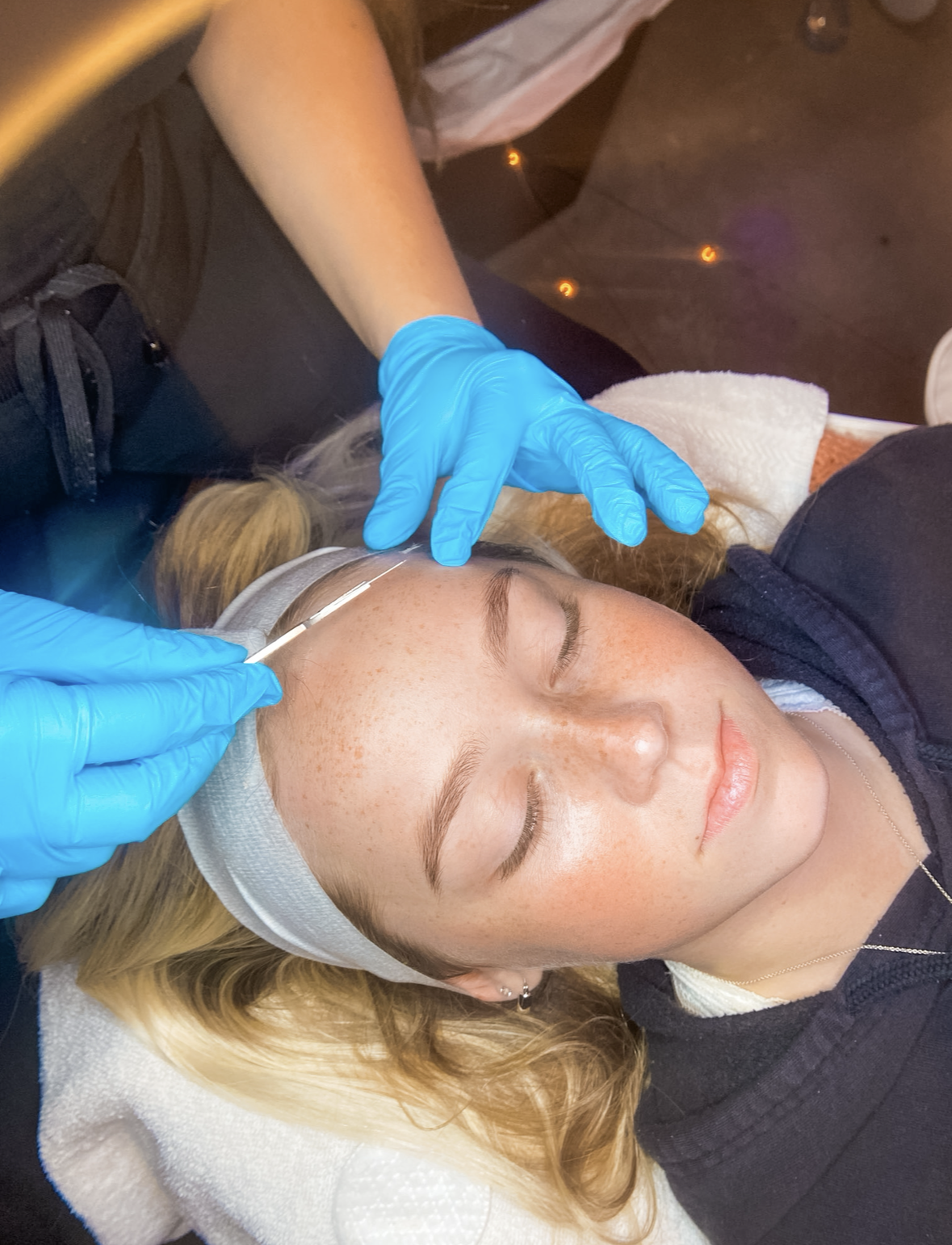 Esthetician performing a DiamondGlow treatment on a client at Shine